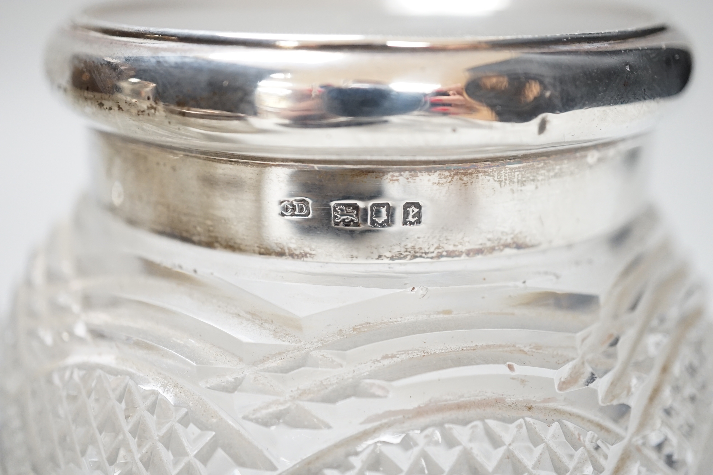 A pair of George V silver mounted cut glass scent bottles, London 1920, 11cm, a similar toilet jar, a hair tidy and a cased two piece christening set